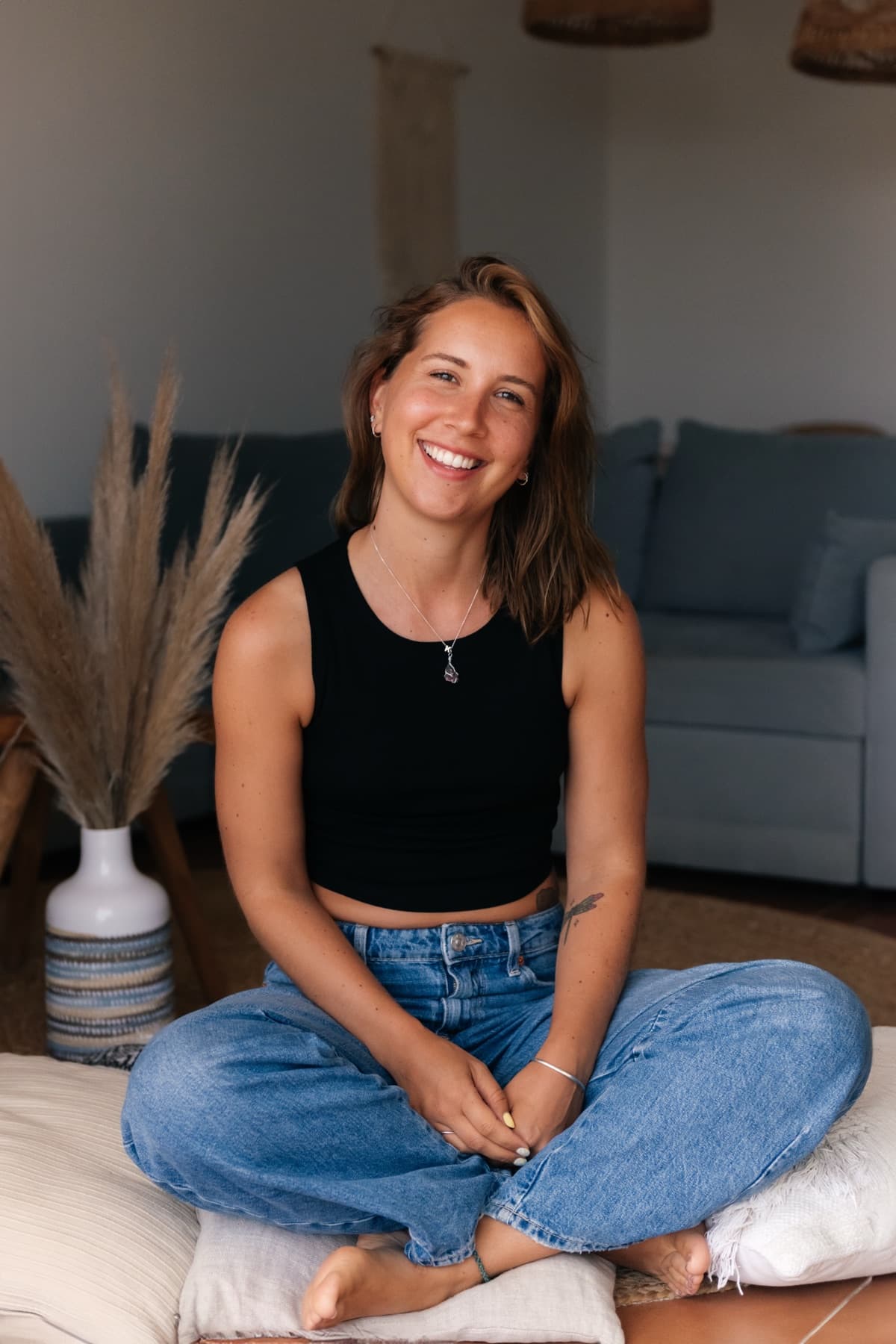 Kristel zit ontspannen in kleermakerszit op vloerkussens